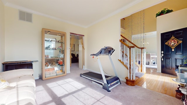 workout room with crown molding, carpet flooring, and an inviting chandelier