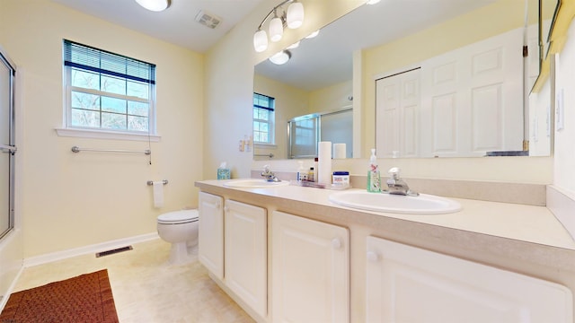 full bathroom featuring vanity, shower / bath combination with glass door, and toilet