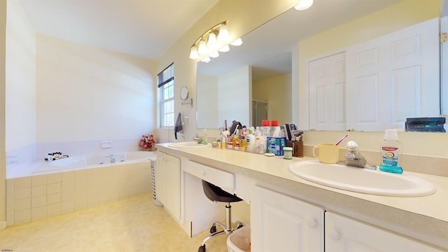 bathroom with vanity and tiled bath