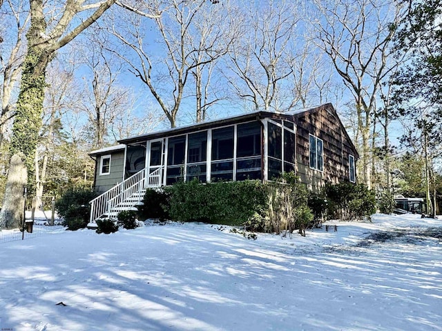 view of front of home featuring stairs and a sunroom