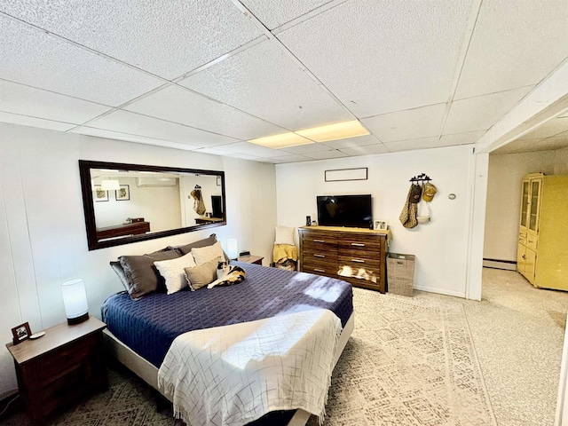 bedroom featuring a baseboard radiator, a paneled ceiling, and baseboards