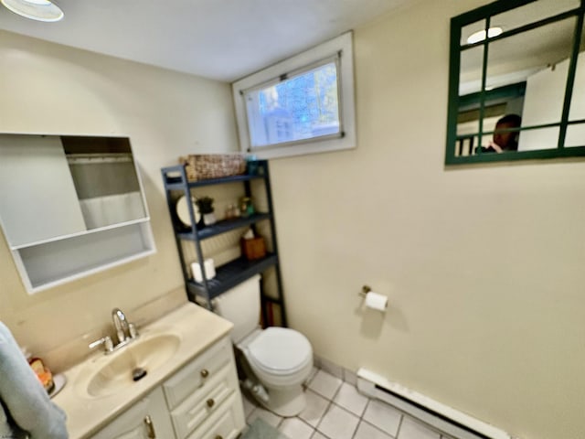 bathroom with toilet, a baseboard heating unit, vanity, baseboards, and tile patterned floors