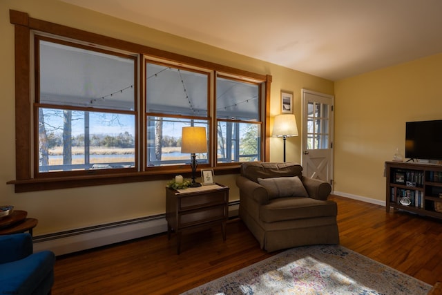 living room with baseboards, a baseboard heating unit, and dark wood-type flooring