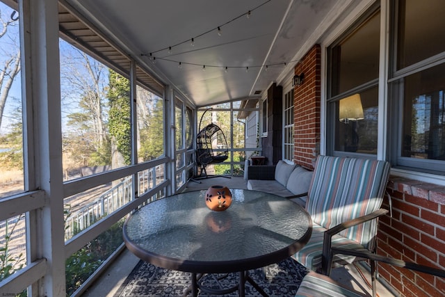 sunroom featuring rail lighting and plenty of natural light