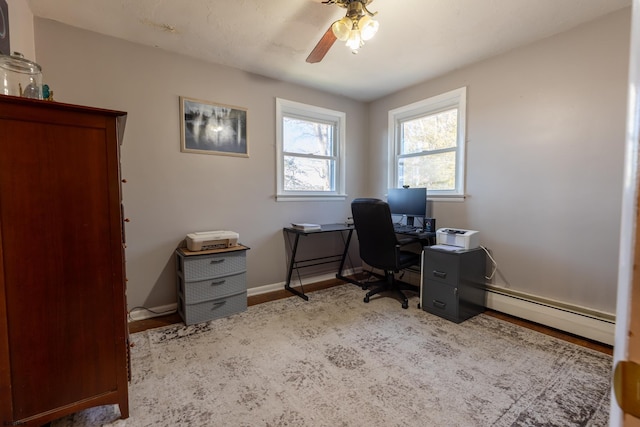 home office with ceiling fan, baseboard heating, wood finished floors, and baseboards