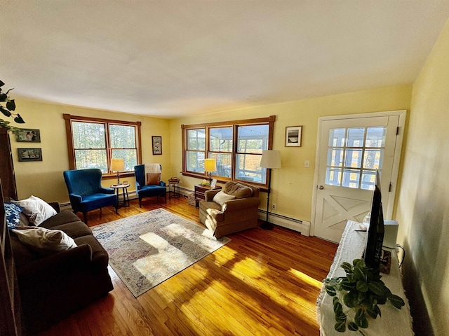 living area featuring hardwood / wood-style floors, a baseboard radiator, and baseboards