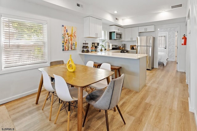 dining area with light hardwood / wood-style flooring and sink