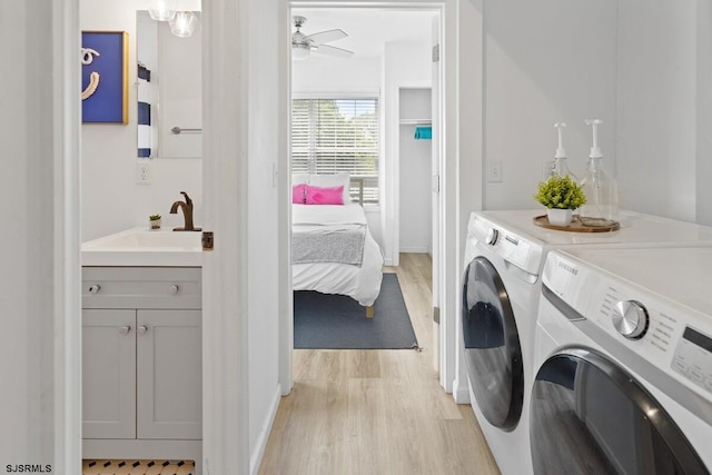 washroom featuring washer and dryer, ceiling fan, light wood-type flooring, and sink