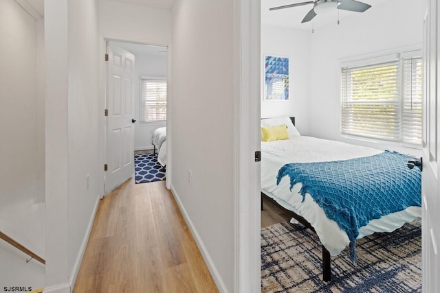 bedroom featuring multiple windows, light hardwood / wood-style floors, and ceiling fan