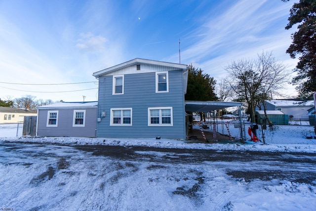 snow covered property with a carport