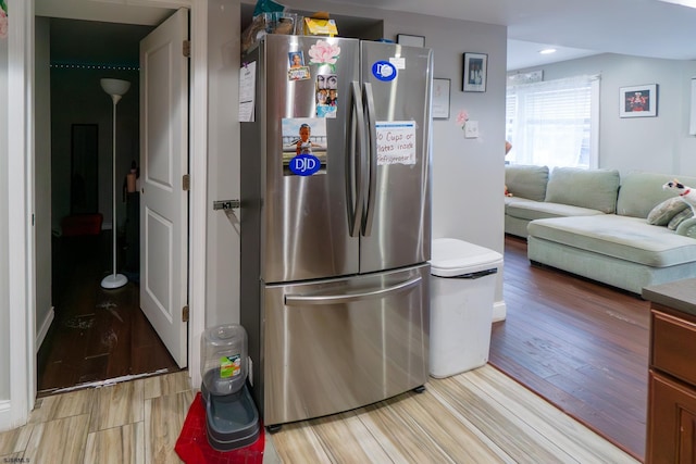 kitchen with stainless steel fridge and light hardwood / wood-style flooring