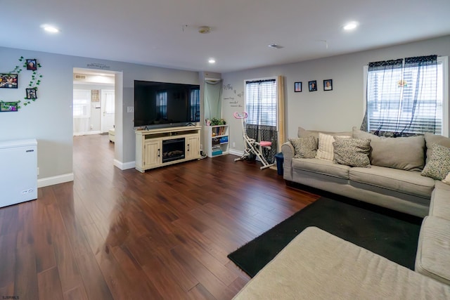 living room featuring plenty of natural light and dark wood-type flooring