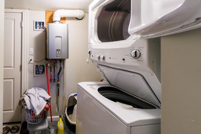 laundry area with stacked washer / drying machine and water heater