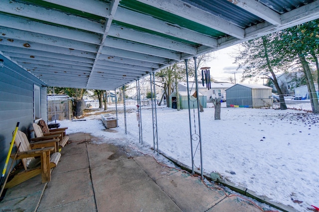 snow covered patio with a shed