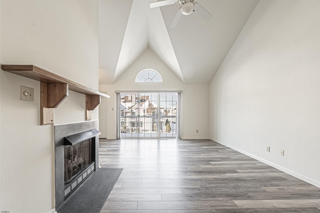 unfurnished living room featuring ceiling fan, wood-type flooring, and lofted ceiling