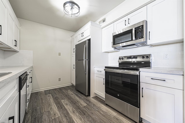 kitchen featuring tasteful backsplash, white cabinets, dark hardwood / wood-style floors, and appliances with stainless steel finishes