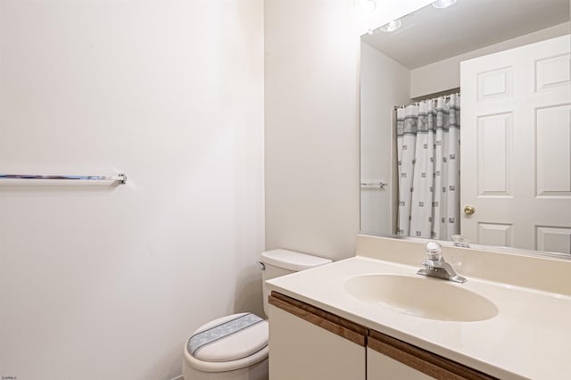 bathroom featuring vanity, a shower with shower curtain, and toilet