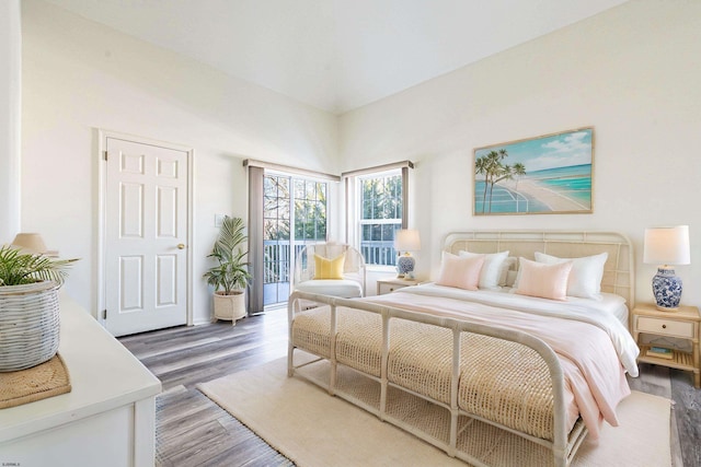 bedroom with access to exterior and dark wood-type flooring