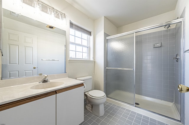 bathroom with tile patterned flooring, vanity, toilet, and walk in shower