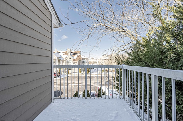 view of snow covered back of property