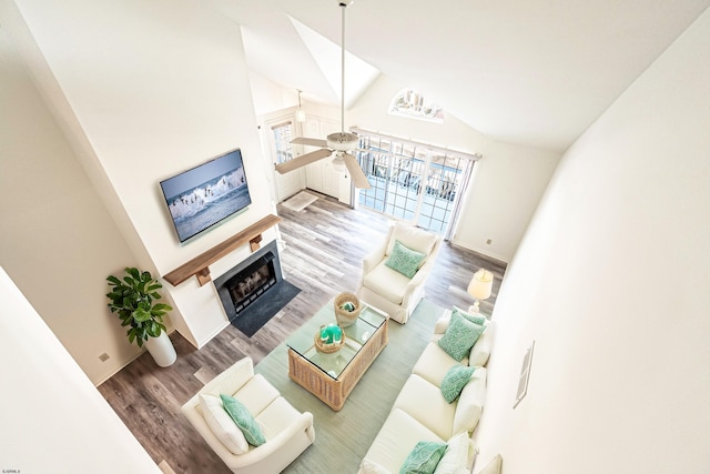 living room with wood-type flooring, high vaulted ceiling, and ceiling fan