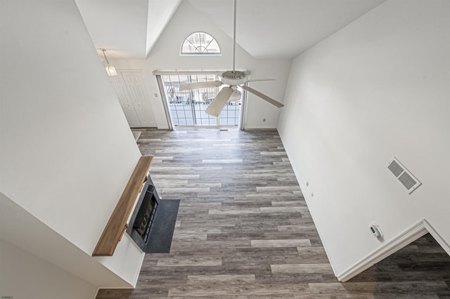 unfurnished living room featuring dark hardwood / wood-style floors, ceiling fan, and high vaulted ceiling