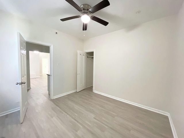 unfurnished bedroom with ceiling fan, light hardwood / wood-style flooring, and a closet