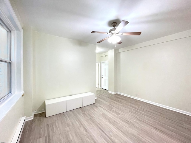 spare room with ceiling fan, light hardwood / wood-style floors, and baseboard heating