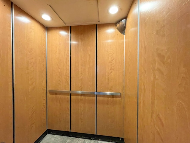 room details featuring wood walls and elevator