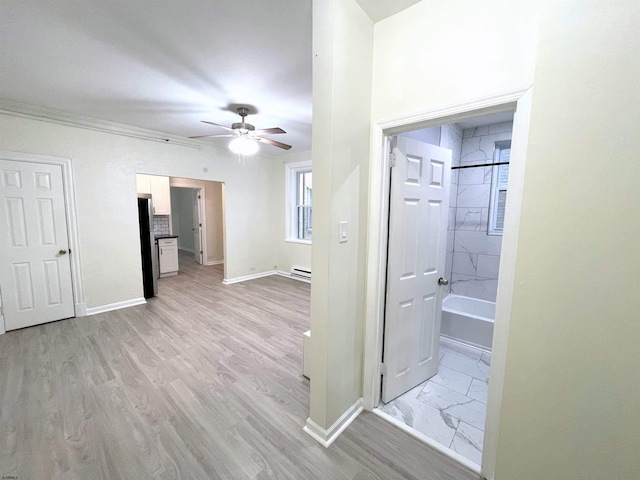 hall featuring ornamental molding, light hardwood / wood-style floors, and a baseboard heating unit