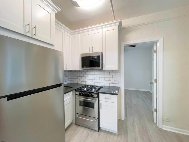 kitchen featuring tasteful backsplash, white cabinets, light hardwood / wood-style floors, and appliances with stainless steel finishes