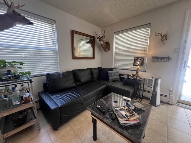 living room with a textured ceiling, a baseboard heating unit, and light tile patterned flooring