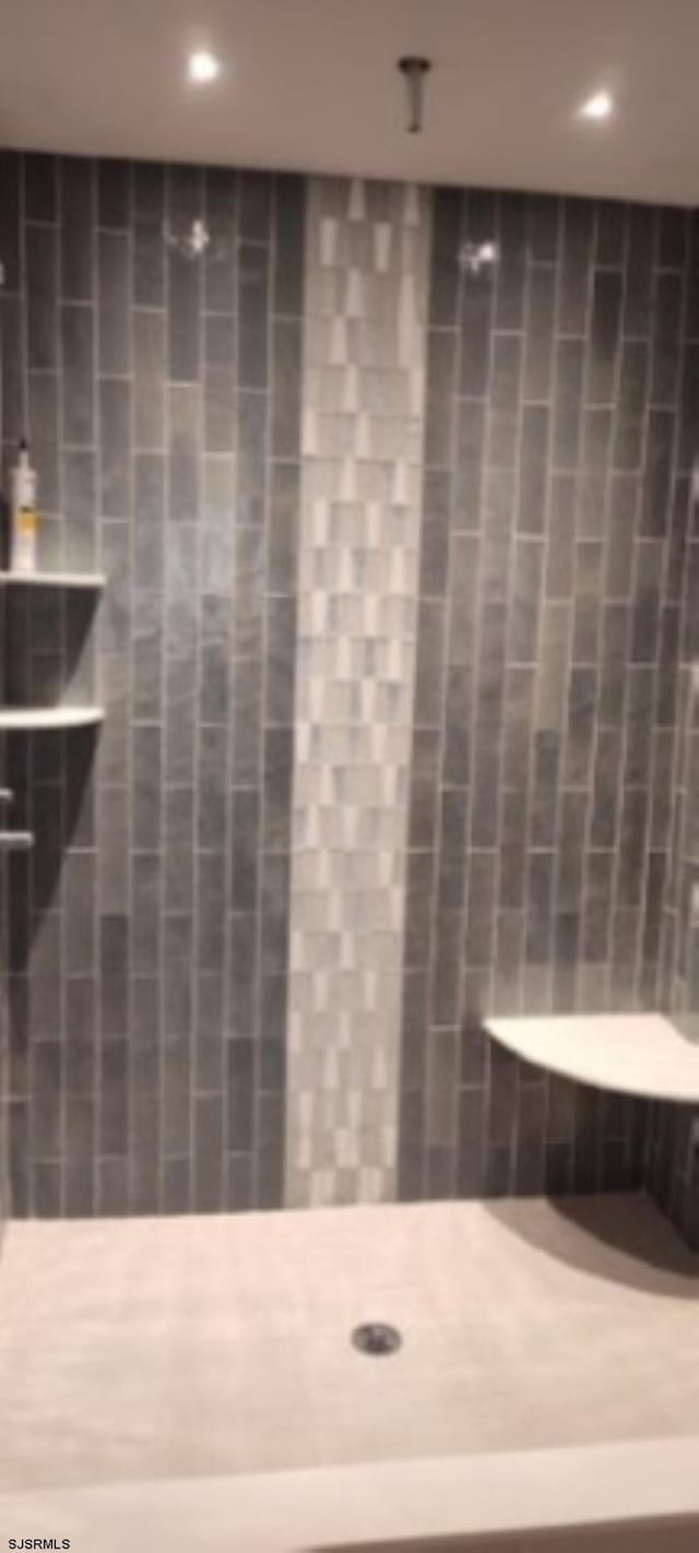 bathroom with a tile shower and recessed lighting