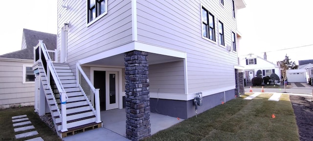 view of home's exterior featuring stairway and a lawn