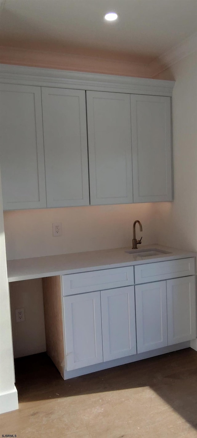 interior details featuring a sink and wood finished floors