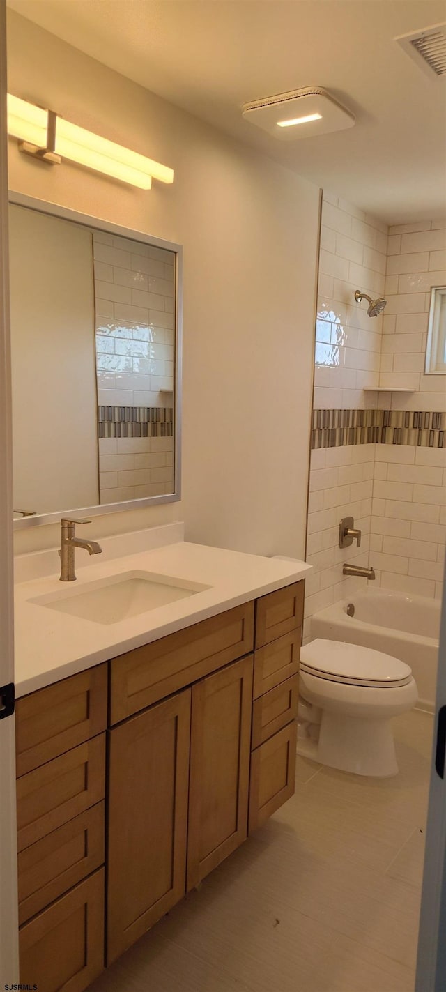 bathroom featuring visible vents, shower / bathtub combination, toilet, and vanity