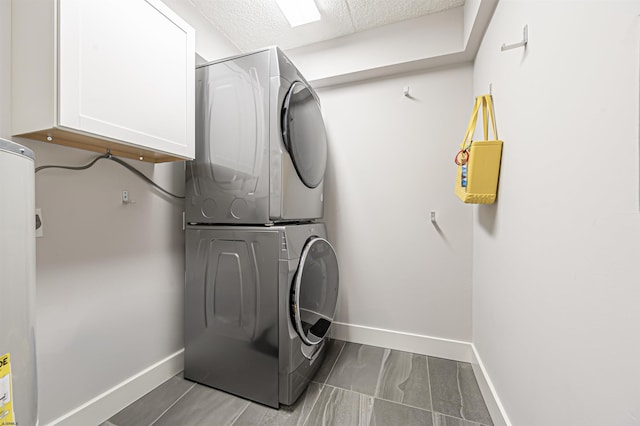 clothes washing area with cabinets and stacked washer and clothes dryer