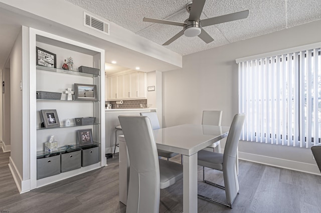 dining area with dark wood-type flooring, a textured ceiling, and ceiling fan