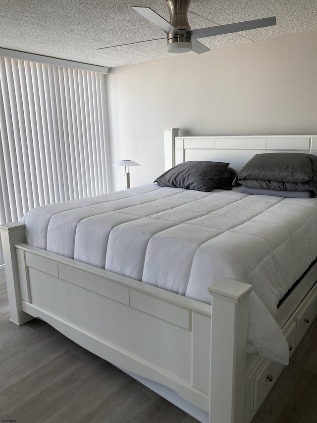 bedroom featuring a textured ceiling, ceiling fan, and dark hardwood / wood-style flooring