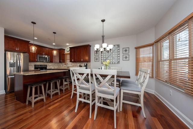 dining space with dark hardwood / wood-style flooring and a notable chandelier