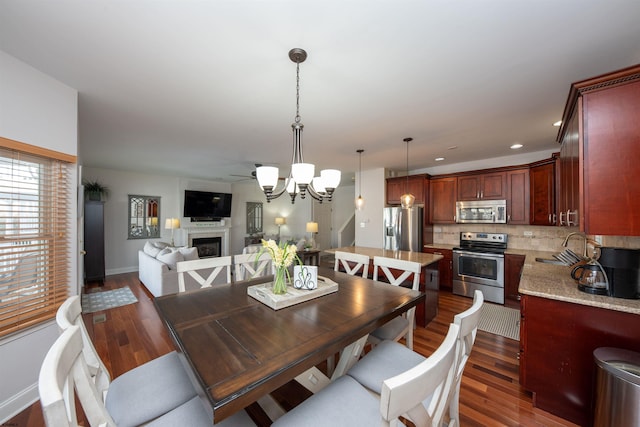 dining room with ceiling fan, dark hardwood / wood-style flooring, and sink