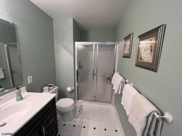 bathroom with vanity, a shower with shower door, and toilet