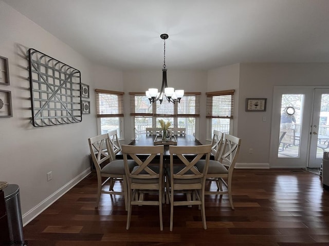 dining space with dark hardwood / wood-style flooring and a notable chandelier