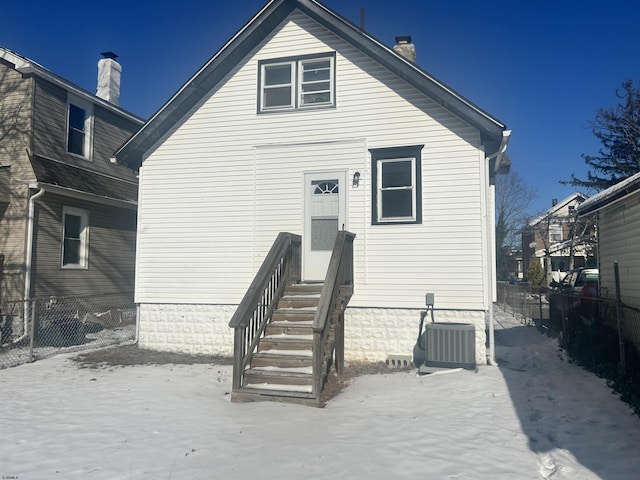 snow covered rear of property with central AC unit