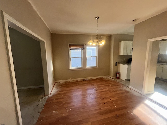 unfurnished dining area with dark wood-type flooring and an inviting chandelier