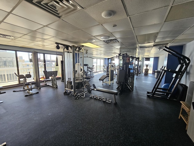 workout area featuring a paneled ceiling and a wealth of natural light