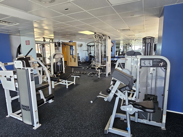 exercise room featuring a drop ceiling and a healthy amount of sunlight