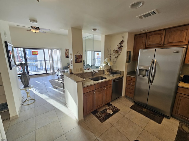 kitchen featuring light tile patterned flooring, appliances with stainless steel finishes, kitchen peninsula, and sink