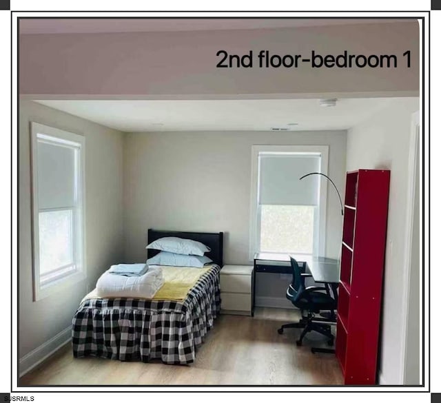 bedroom featuring hardwood / wood-style floors and multiple windows