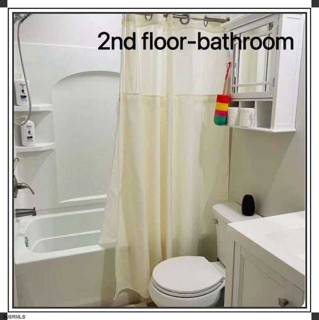 full bathroom with vanity, shower / bath combo with shower curtain, and toilet